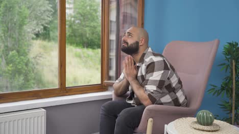 Christian-man-praying-in-front-of-the-window.